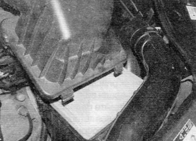 Figure 20.21, b....lift the cover and unhook the two retaining tabs from the air filter housing…