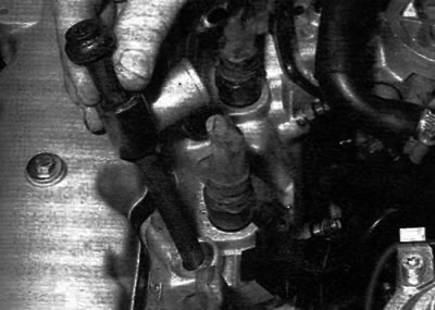 Figure 13.20. Unscrewing the cylinder head mounting bolt and removing the spacer