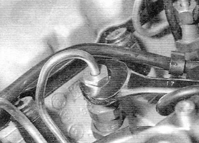 Figure 5.12, a. Disconnecting the fuel line union on the injector