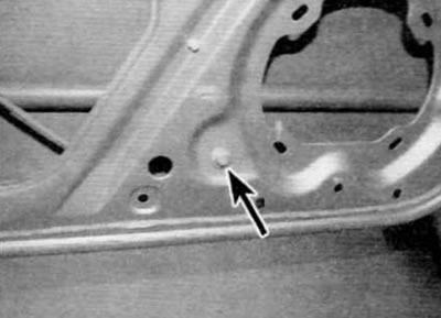 Figure 15.12. Loosen the lower bolt (marked with an arrow) window lifter mounts to the door