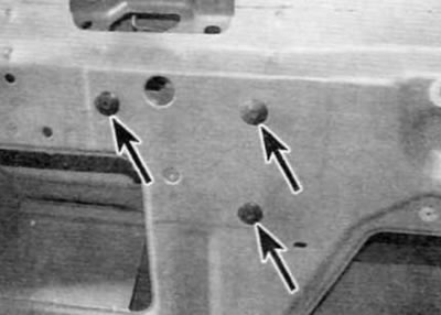 Figure 17.7, a. Remove the three screws securing the trunk lid lock (marked with arrows)...