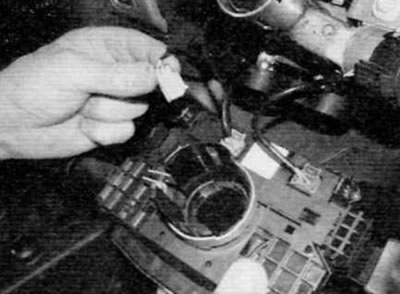 Rysunek 4.11, d. Odwróć urządzenie i odłącz złącza elektryczne (późne modele)