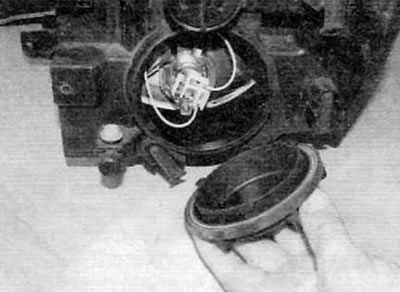 Рис. 5.7. Снимите пластмассовую крышку с фары (поздние модели)