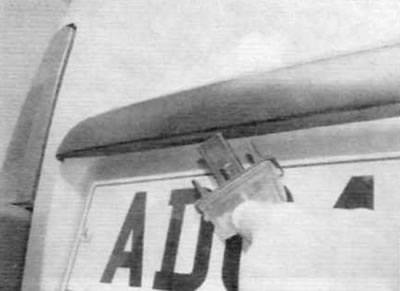 Рис. 5.57, б. ...и вытолкните фонарь из двери (модели с двухстворчатой дверью багажного отделения)