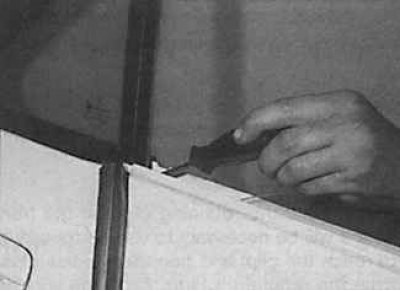 12. Развийте долния винт, закрепващ водача на задното стъкло.